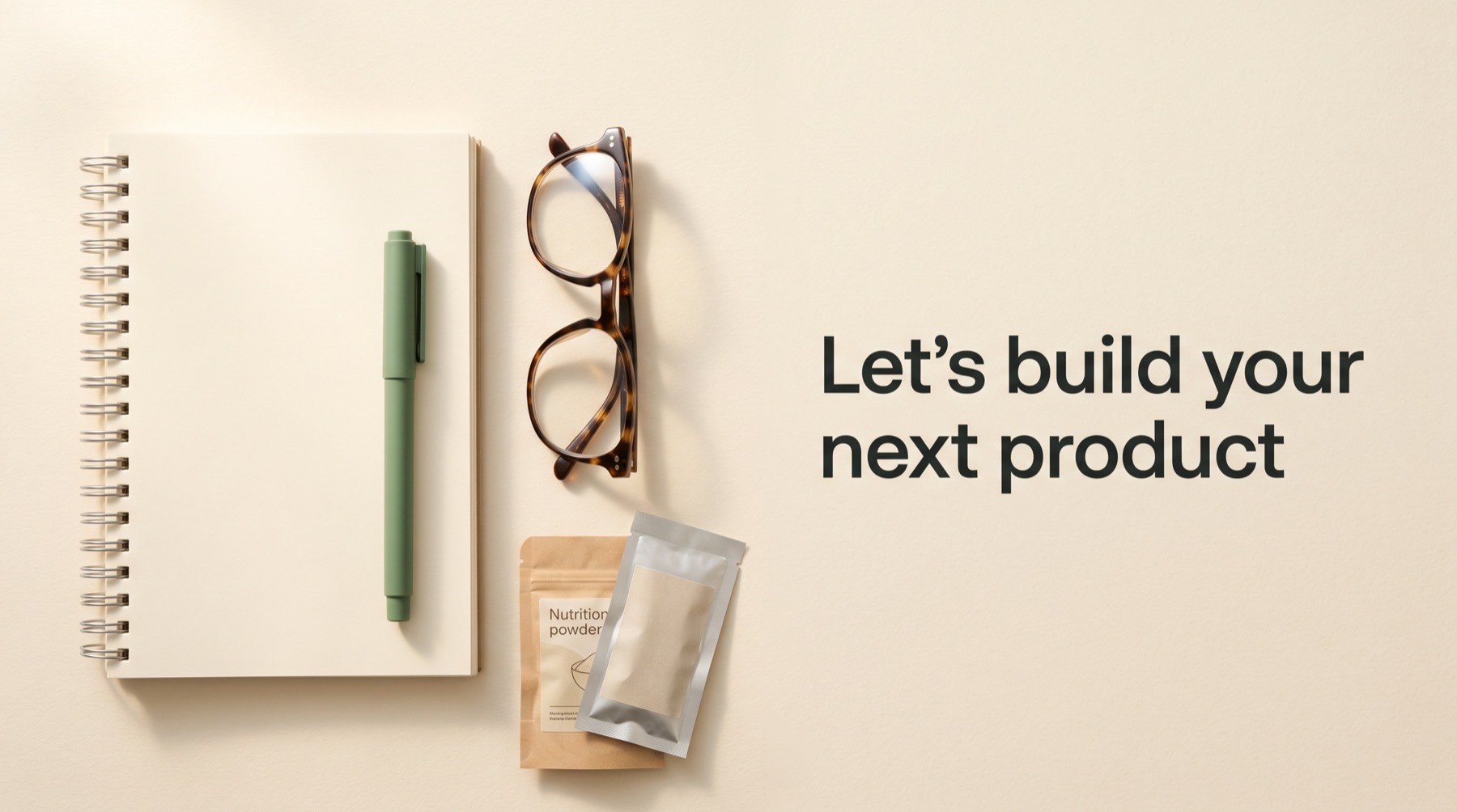A notepad, a pen and two sample pouches on a desk
